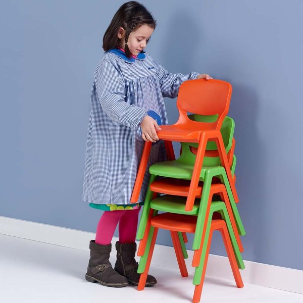 Mobiliario Escolar Los Alcázares: Niña en edad escolar con babi de cuadros apilando sillas escolares monobloque de colores naranja y verde vibrantes sobre suelo de madera en Los Alcázares.